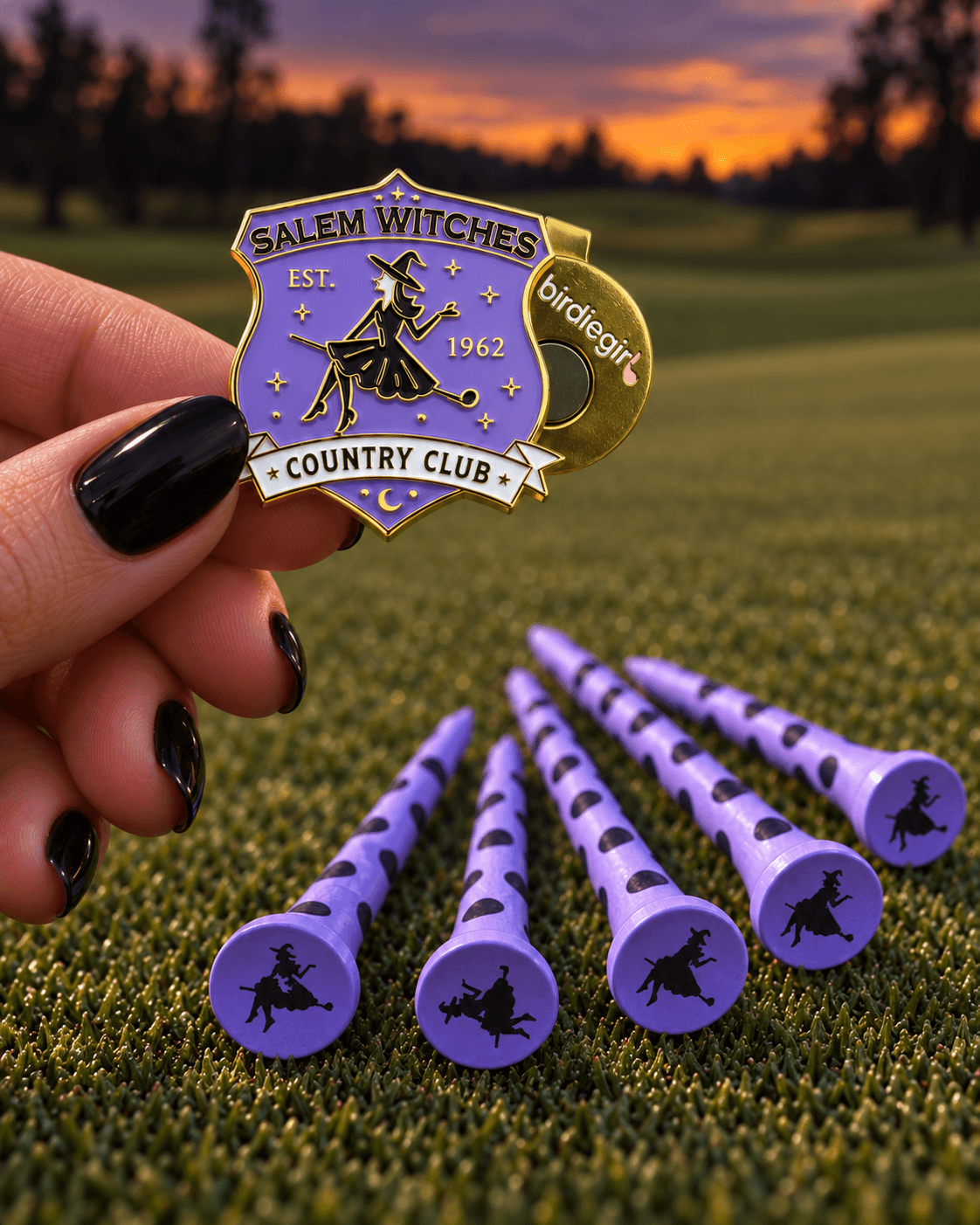 hand holding salem witches country club golf ball marker with witch tees behind Birdie Girl October Subscription box
