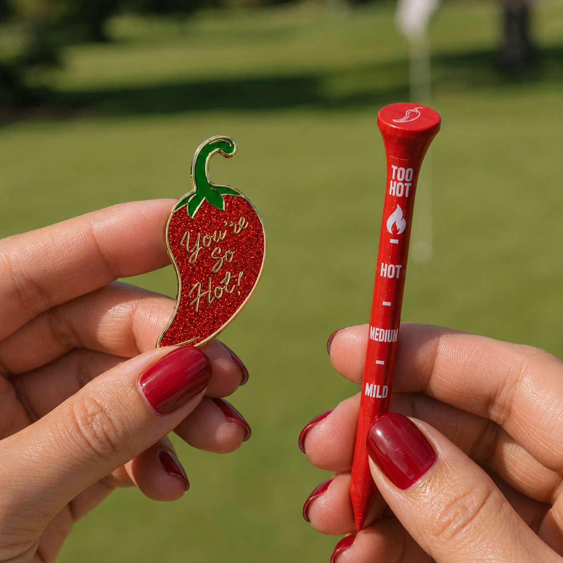Woman holding a youre so hot ball marker and too hot tees