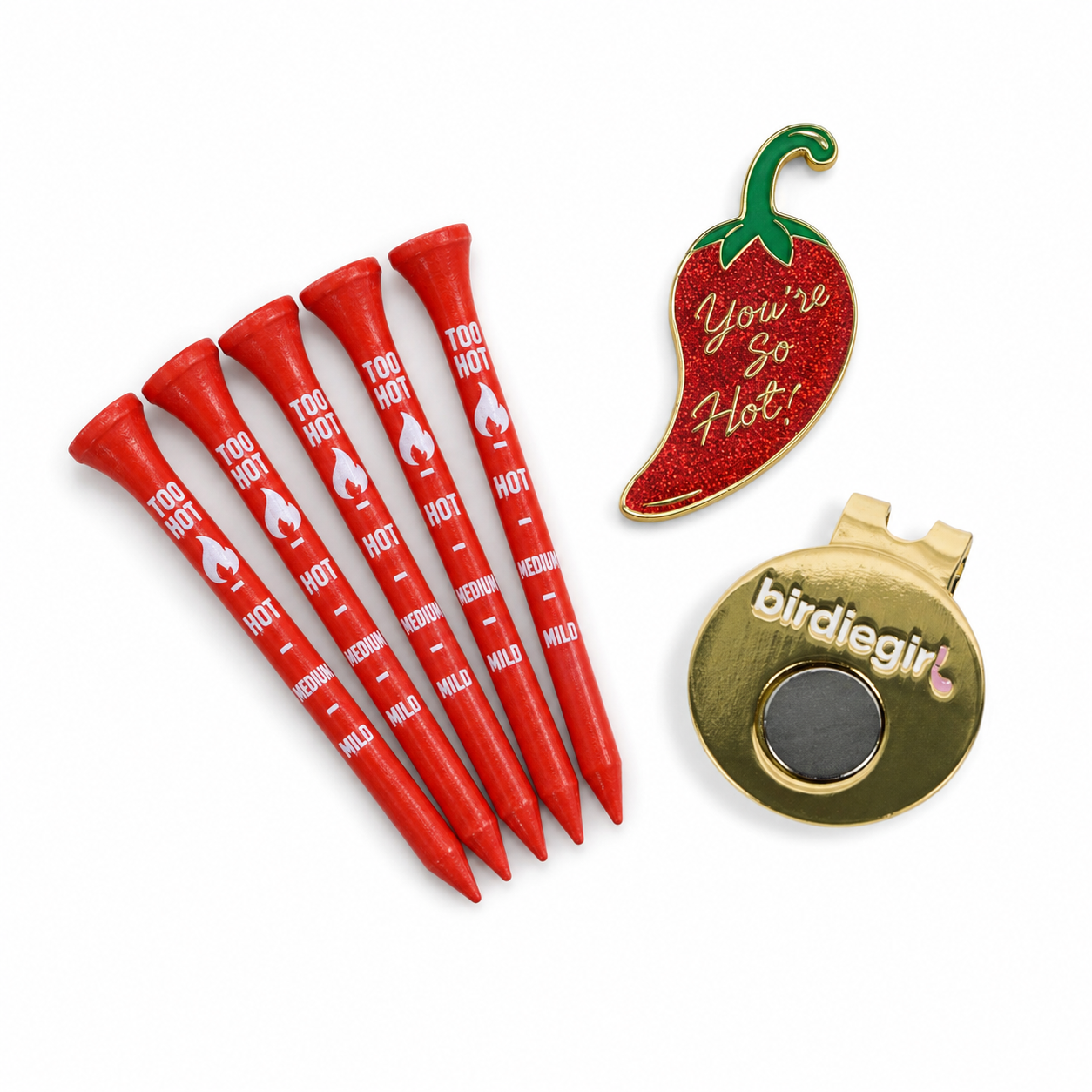 A golf-themed novelty accessory set on a white background, featuring five red tees printed with heat level markings and the words 'TOO HOT', a red chili pepper pin with the text 'You're So Hot!', and a gold birdie ball marker with the brand name 'birdiegirl'.